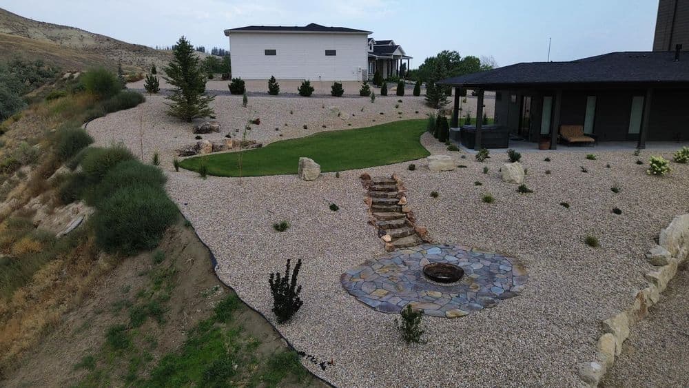 Modern landscape design featuring a gravel yard, fire pit, and contemporary homes in the background.